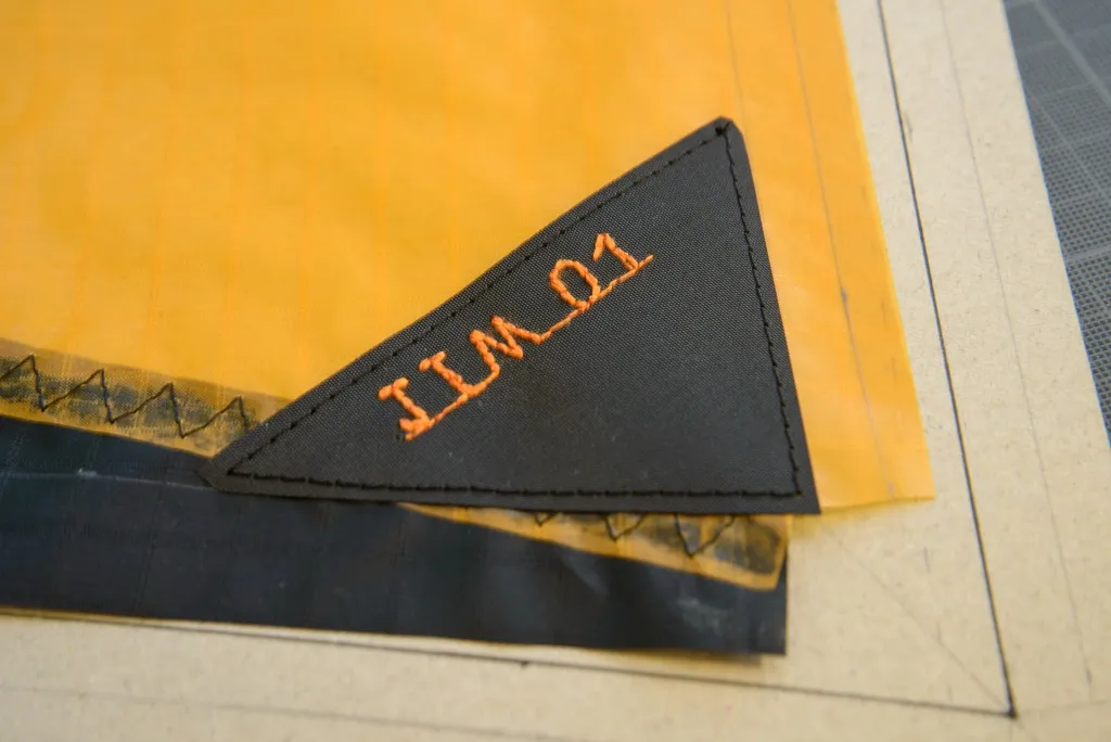 Collage et couture des renforts sur la voile
